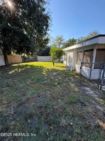 a view of a house with backyard and a tree
