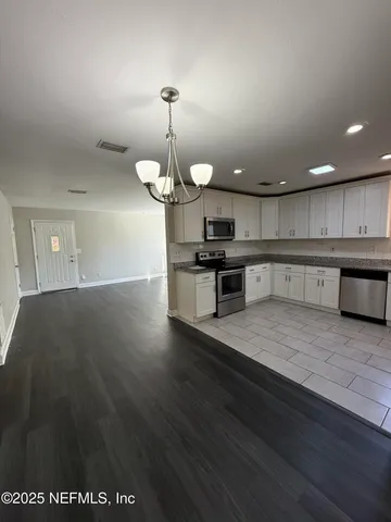 a view of a kitchen with a sink stainless steel appliances and cabinets