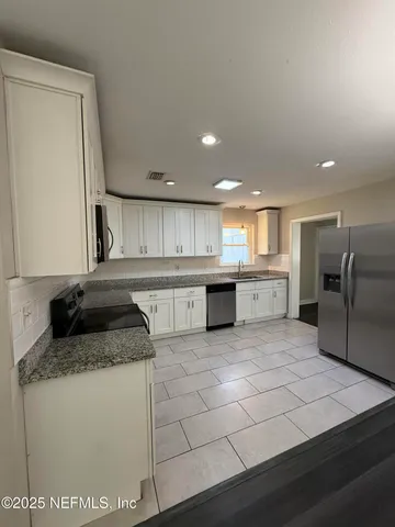 a kitchen with stainless steel appliances granite countertop a sink and a stove