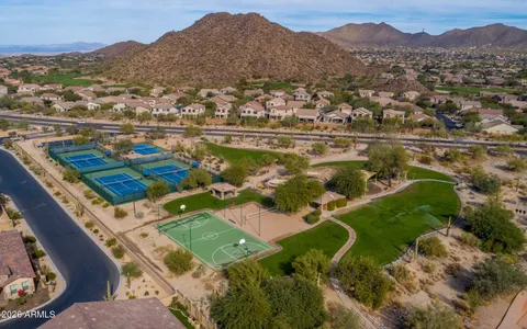 an aerial view of residential houses with outdoor space and trees