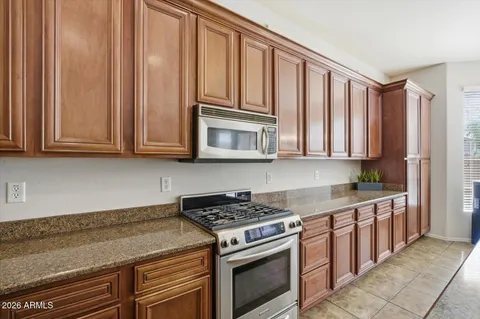 a kitchen with stainless steel appliances granite countertop a sink a stove and a refrigerator