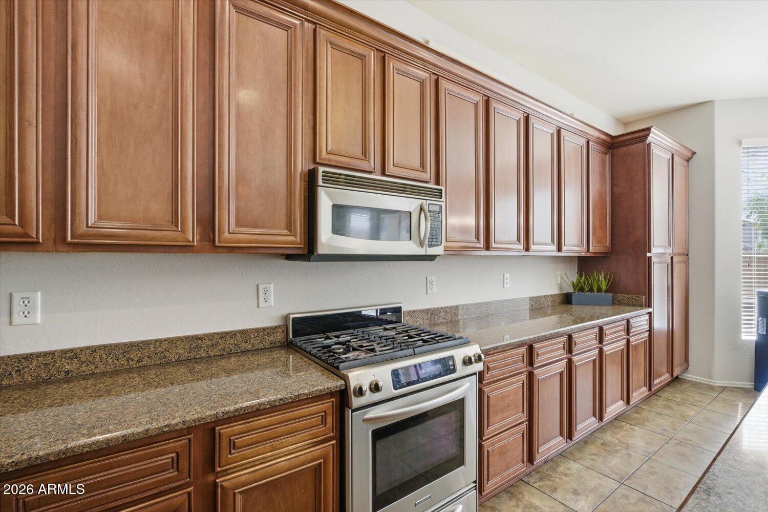 7253 East Nathan Street Mesa, AZ 85207 - Photo 7 of 34 a kitchen with stainless steel appliances granite countertop cabinets and a stove top oven