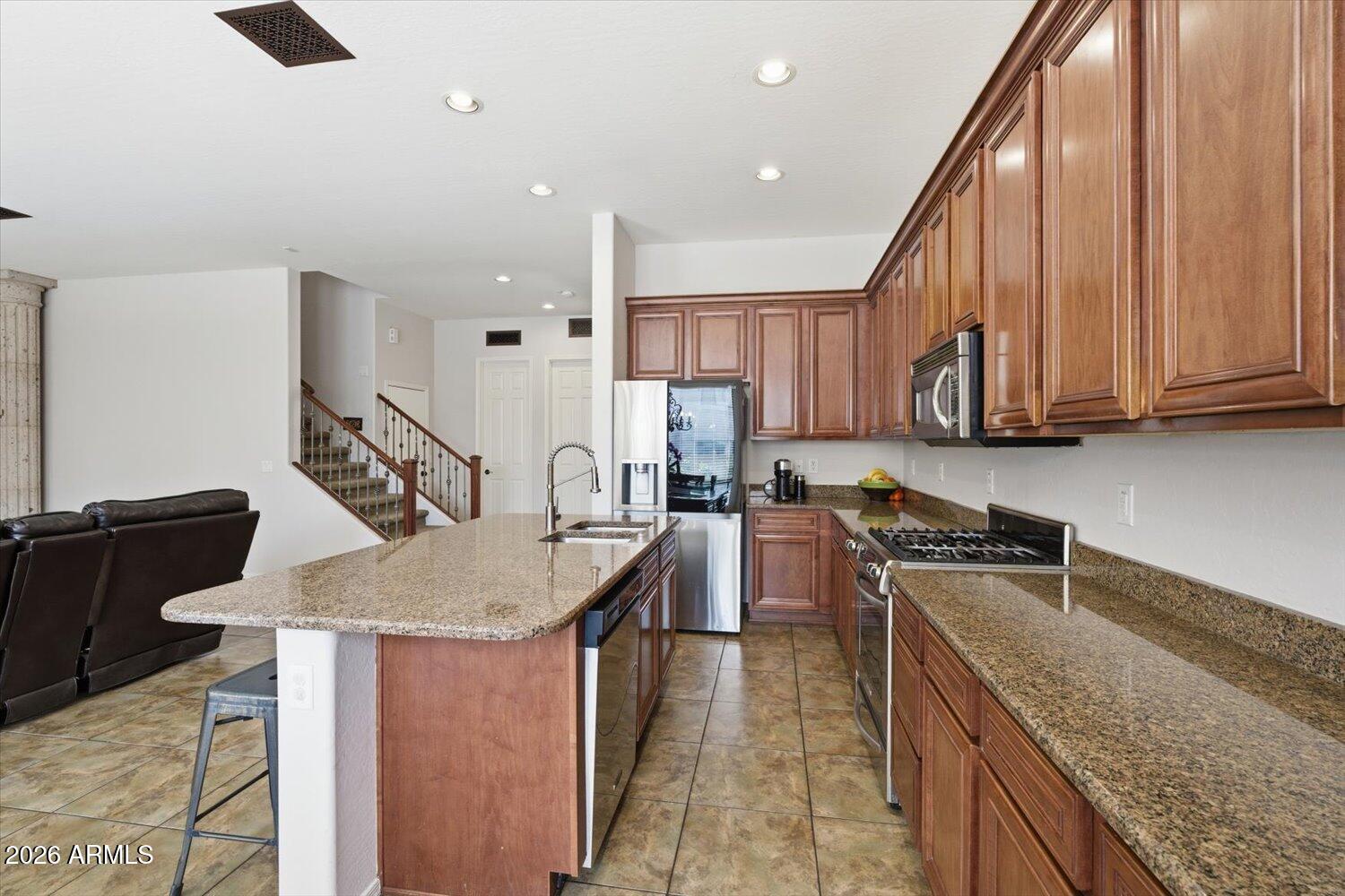 7253 East Nathan Street Mesa, AZ 85207 - Photo 8 of 34 a kitchen with stainless steel appliances granite countertop a sink a stove and a refrigerator