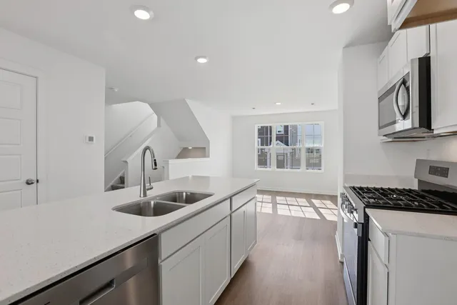 a kitchen with stainless steel appliances granite countertop a sink and a stove
