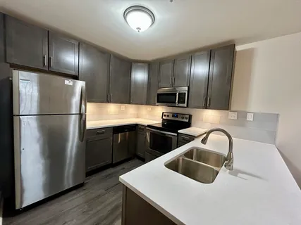 a kitchen with granite countertop a refrigerator and a sink