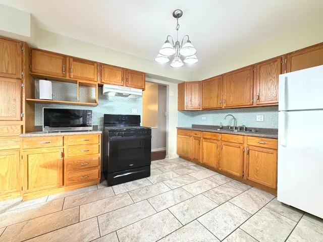a kitchen with stainless steel appliances granite countertop a stove cabinets and microwave