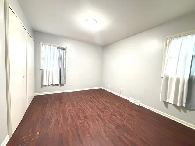 an empty room with wooden floor and window