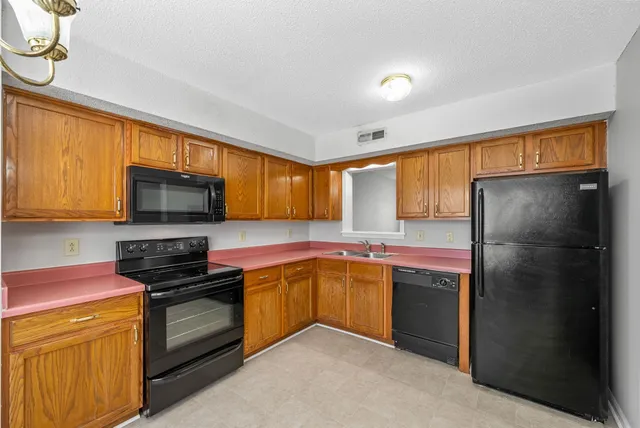 a kitchen with stainless steel appliances granite countertop a stove a sink dishwasher a refrigerator and a microwave