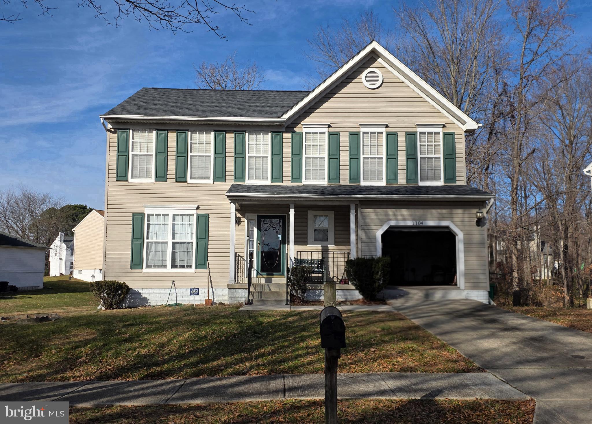 Charming two-story home with green shutters.