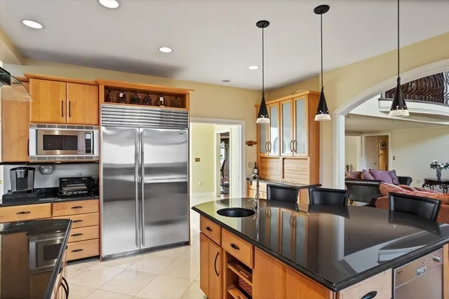 a kitchen with stainless steel appliances granite countertop a refrigerator a oven and a sink