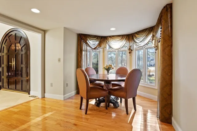 a dining room with furniture a chandelier and wooden floor