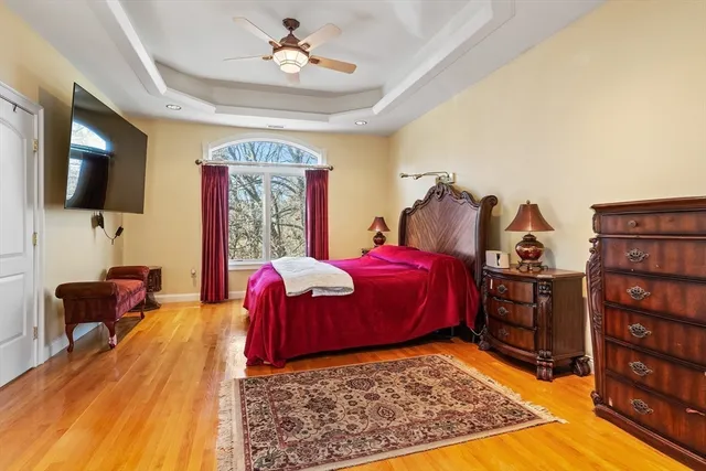 a spacious bedroom with a bed and wooden floor