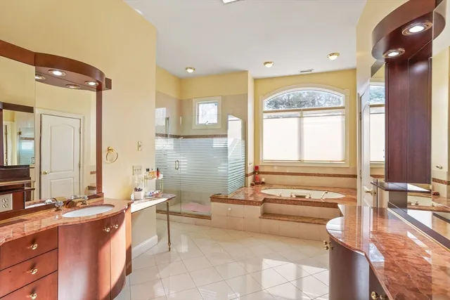 a spacious bathroom with a tub a double vanity sink a mirror and a bathtub