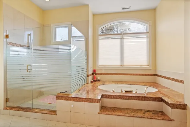 a bathroom with a tub sink and mirror