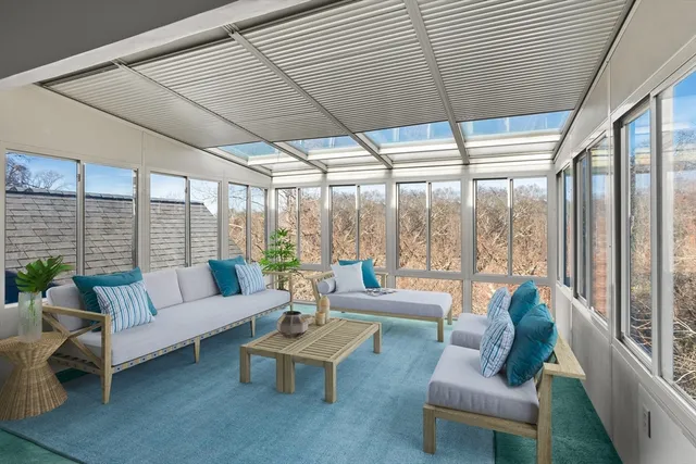 a living room with furniture and floor to ceiling windows