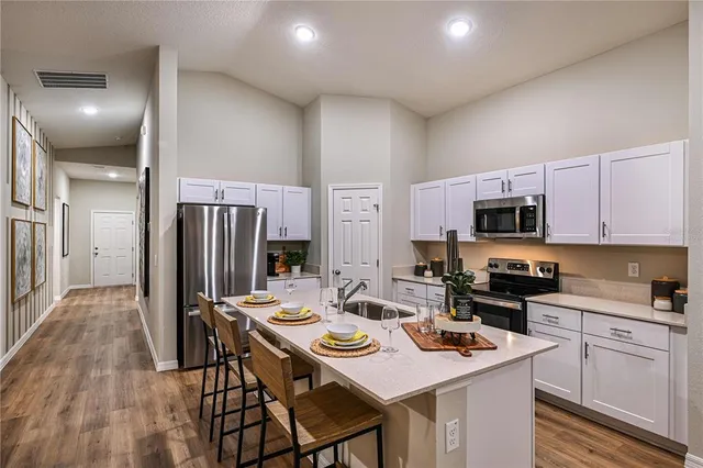 a kitchen that has a lot of cabinets a sink and appliances