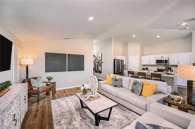 a living room with furniture kitchen view and a table