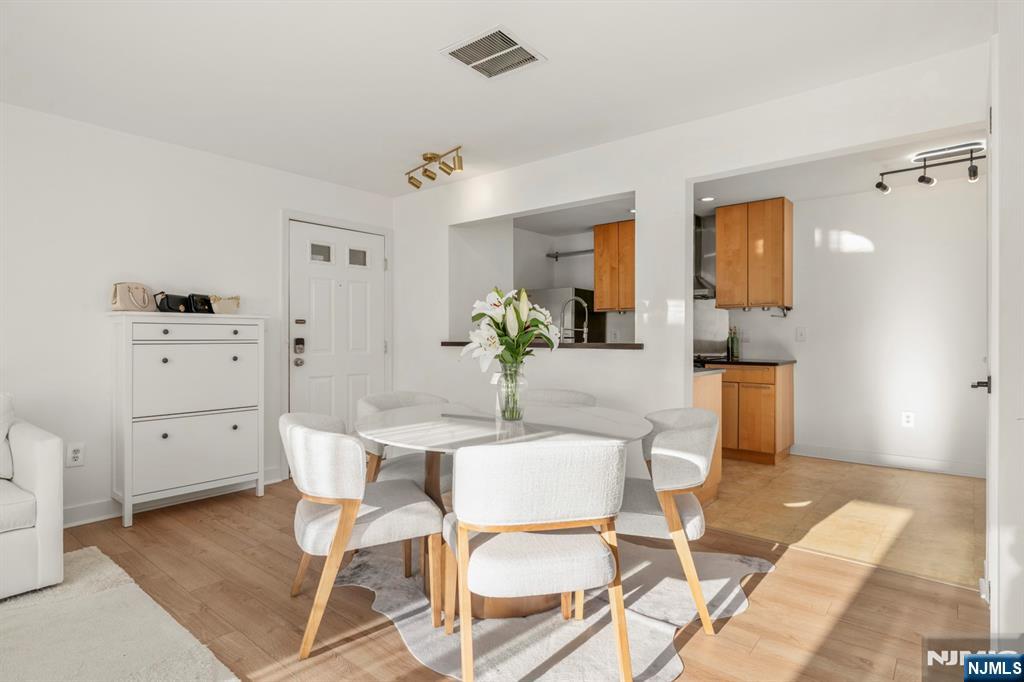 100 Crown Court, Unit 482 Edgewater, NJ 07020 - Photo 5 of 16 a dining room with furniture and wooden floor