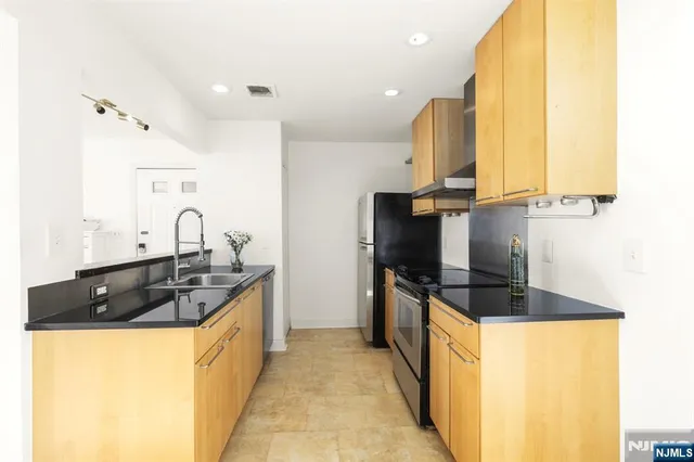 a kitchen with stainless steel appliances a sink and a refrigerator