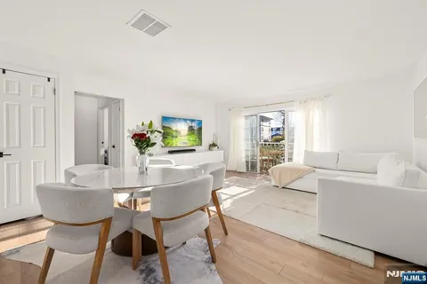 a living room with furniture a wooden floor and a potted plant