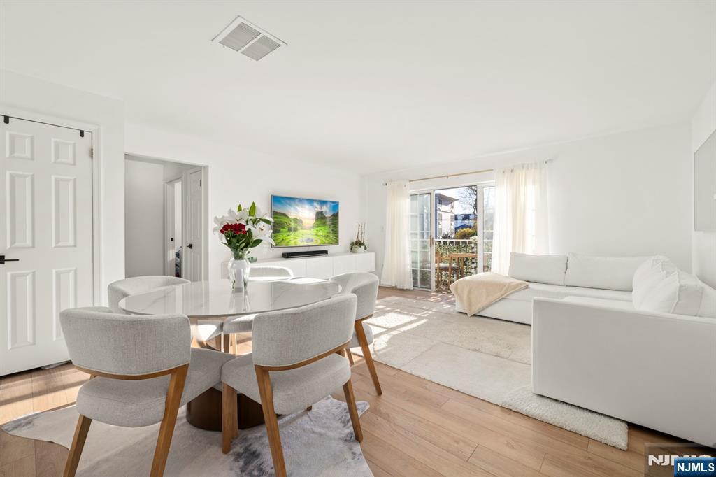 100 Crown Court, Unit 482 Edgewater, NJ 07020 - Photo 7 of 16 a living room with furniture a wooden floor and a potted plant