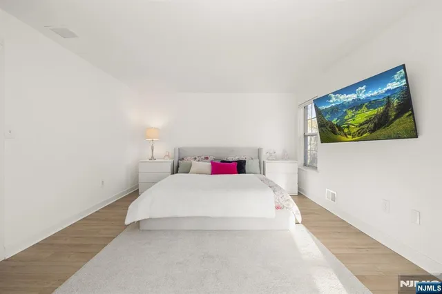 a bedroom with a bed and a painting on the wall