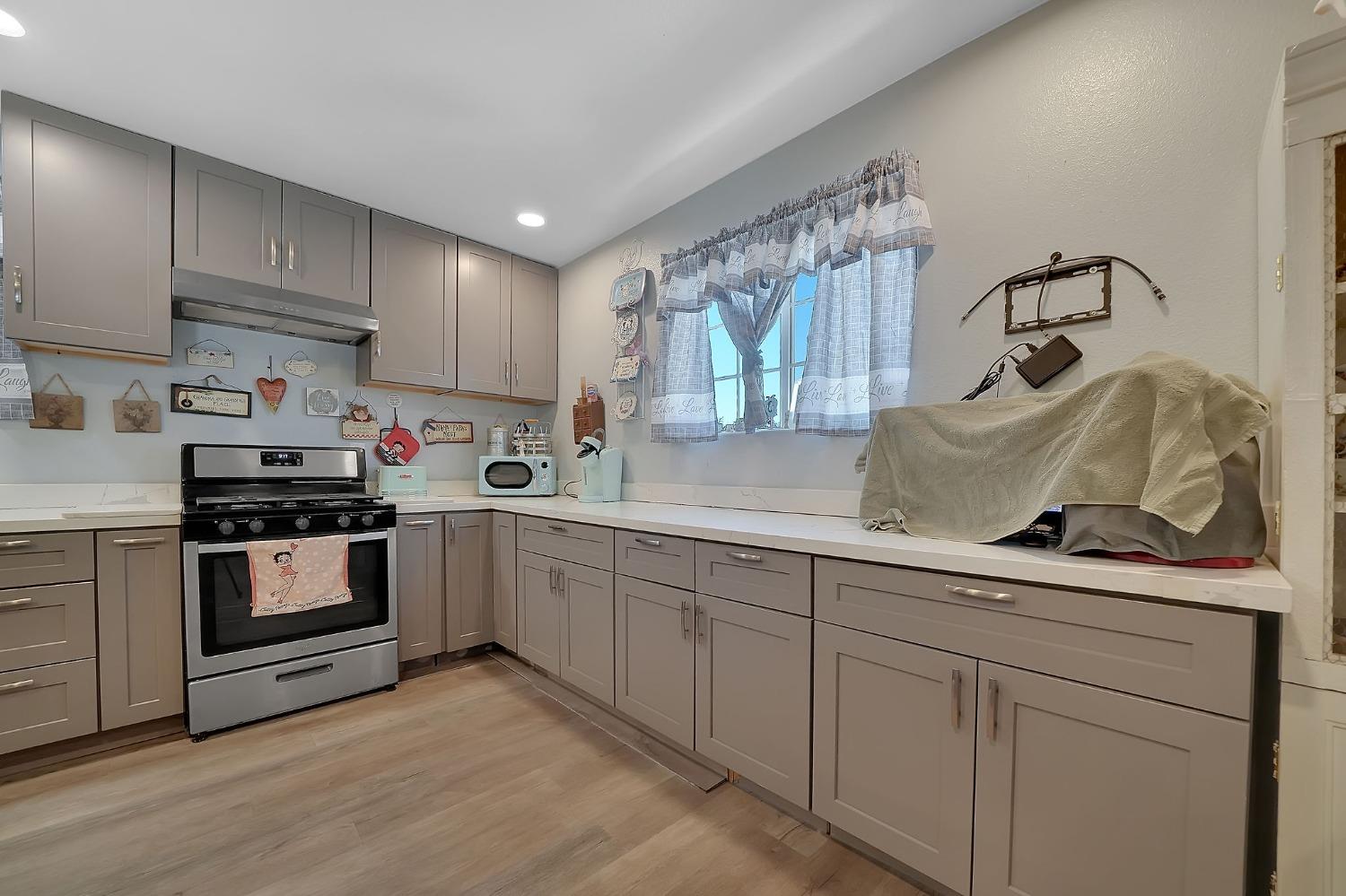 3585 South Burson Road Valley Springs, CA 95252 - Photo 52 of 99 a kitchen with granite countertop white cabinets and white appliances