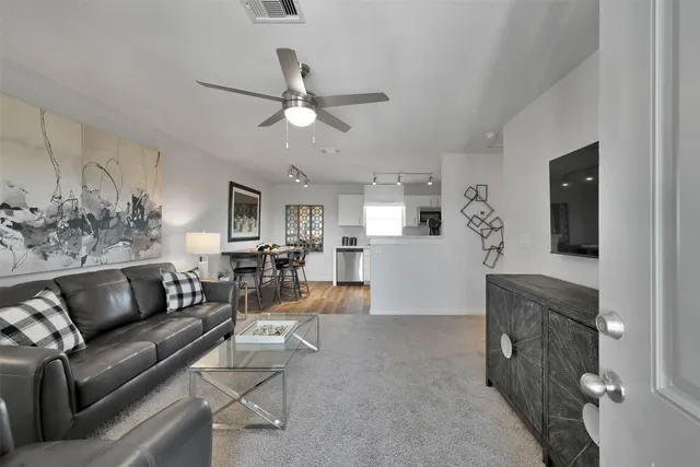 a living room with furniture and a wooden floor