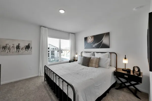 a bedroom with a bed and a flat tv screen on the dresser