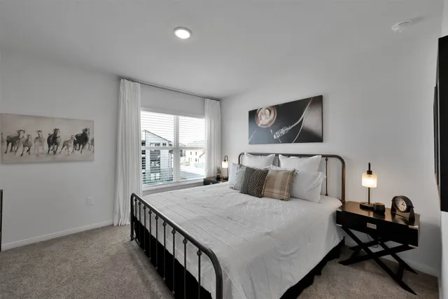 a bedroom with a bed and a flat tv screen on the dresser