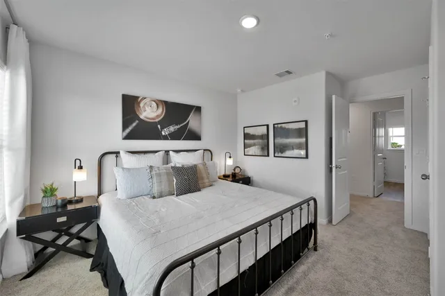a bedroom with a large bed and paintings on the wall