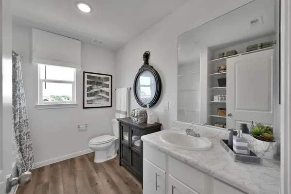 a bathroom with a toilet a sink and a mirror