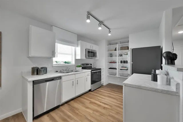 a kitchen with refrigerator cabinets and wooden floor