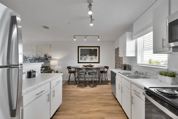 a kitchen with stainless steel appliances a sink stove and cabinets