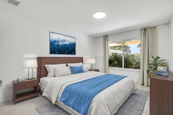 a bedroom with a bed and a painting on the wall