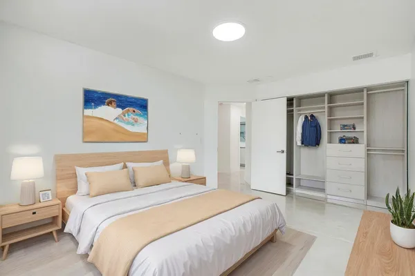 a bedroom with a bed and a potted plant