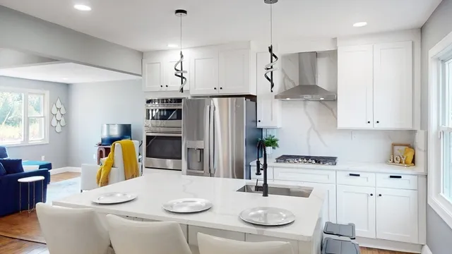 a kitchen with stainless steel appliances kitchen island granite countertop a table and chairs in it
