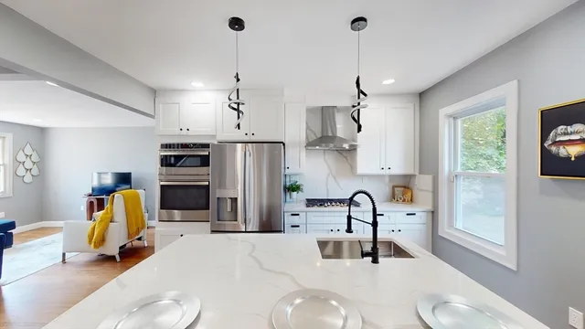 a kitchen with stainless steel appliances kitchen island granite countertop a sink and a refrigerator