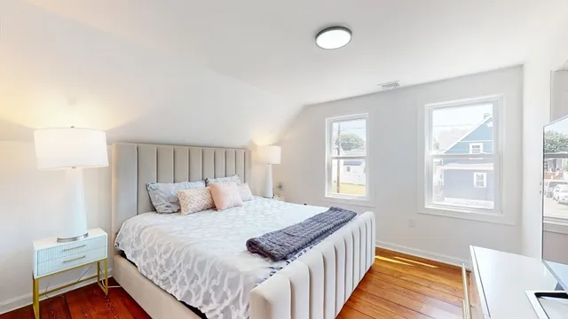 a bedroom with a bed and wooden floor
