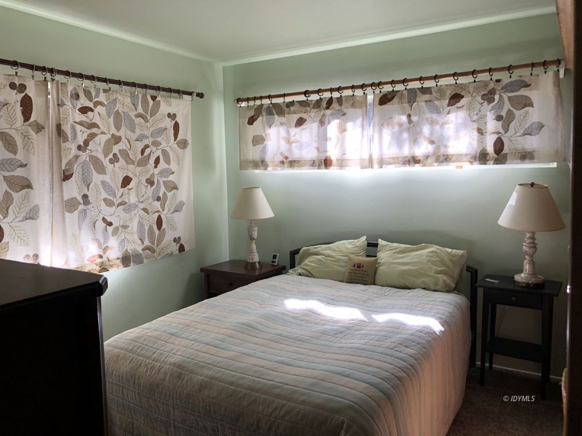 52572 Idyllmont Road Idyllwild, CA 92549 - Photo 5 of 13 a bedroom with a bed and a lamp on the dresser
