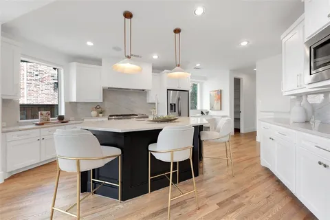 a large kitchen with a counter space a sink stainless steel appliances and cabinets