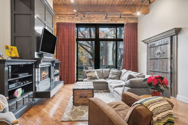 a living room with furniture a flat screen tv and a floor to ceiling window
