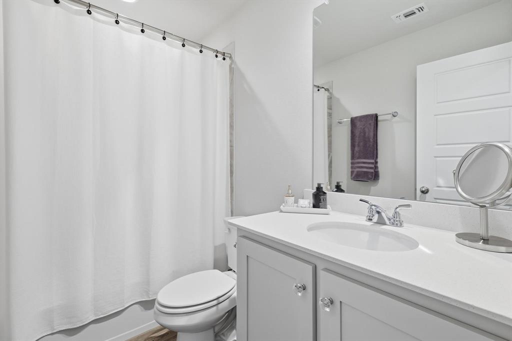 6092 Bursey Road Watauga, TX 76148 - Photo 21 of 23 a bathroom with a sink a toilet and a mirror