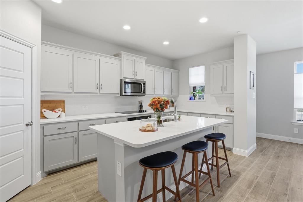 6092 Bursey Road Watauga, TX 76148 - Photo 9 of 23 a kitchen with appliances cabinets and wooden floor