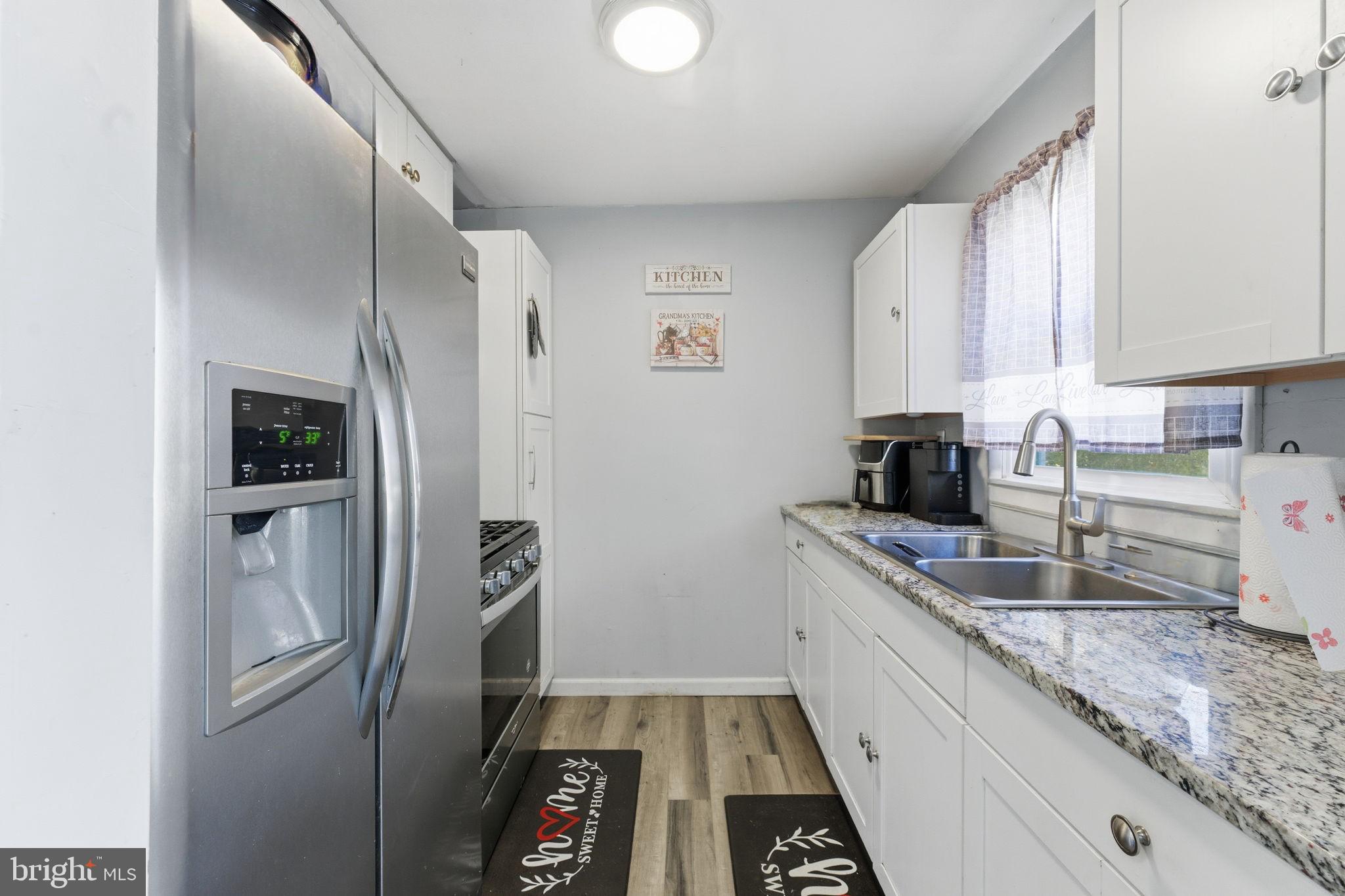7812 Amherst Drive Manassas, VA 20111 - Photo 10 of 36 a kitchen with stainless steel appliances granite countertop a refrigerator and a sink