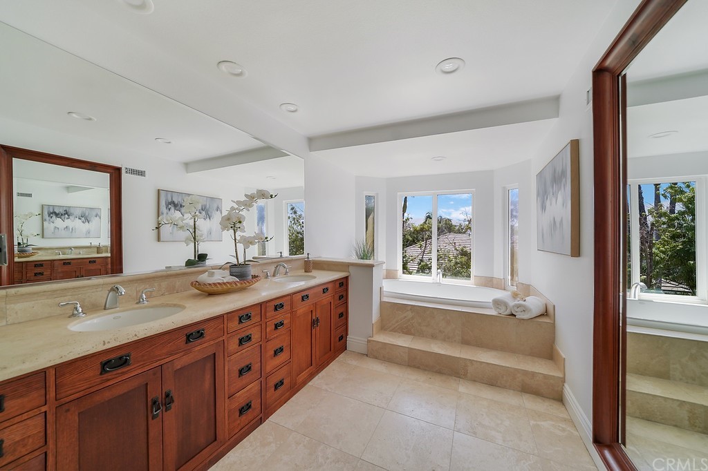 1902 Derby Drive North Tustin, CA 92705 - Photo 37 of 67 a spacious bathroom with a double vanity sink a large mirror and a bathtub next to a window
