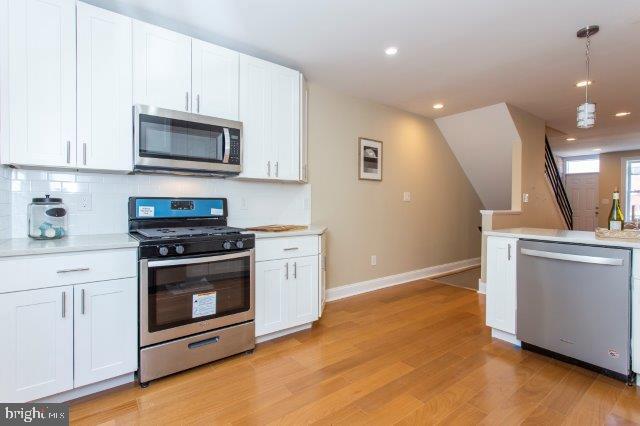 2026 McClellan Street Philadelphia, PA 19145 - Photo 13 of 32 a kitchen with stainless steel appliances granite countertop a stove a microwave and a hard wood floors
