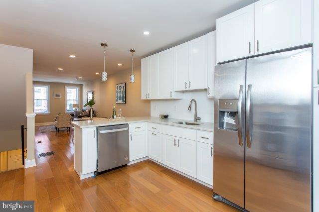 2026 McClellan Street Philadelphia, PA 19145 - Photo 14 of 32 a kitchen with stainless steel appliances granite countertop a refrigerator a sink dishwasher a stove and white cabinets with wooden floor