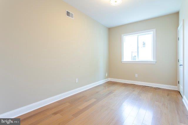 2026 McClellan Street Philadelphia, PA 19145 - Photo 17 of 32 an empty room with wooden floor and windows
