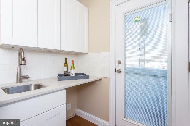 2026 McClellan Street Philadelphia, PA 19145 - Photo 26 of 32 a kitchen with stainless steel appliances granite countertop a sink and a white cabinets with wooden floor
